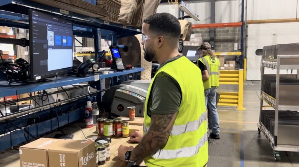 Kase warehouse staff member inputting information on computer for retail fulfillment services